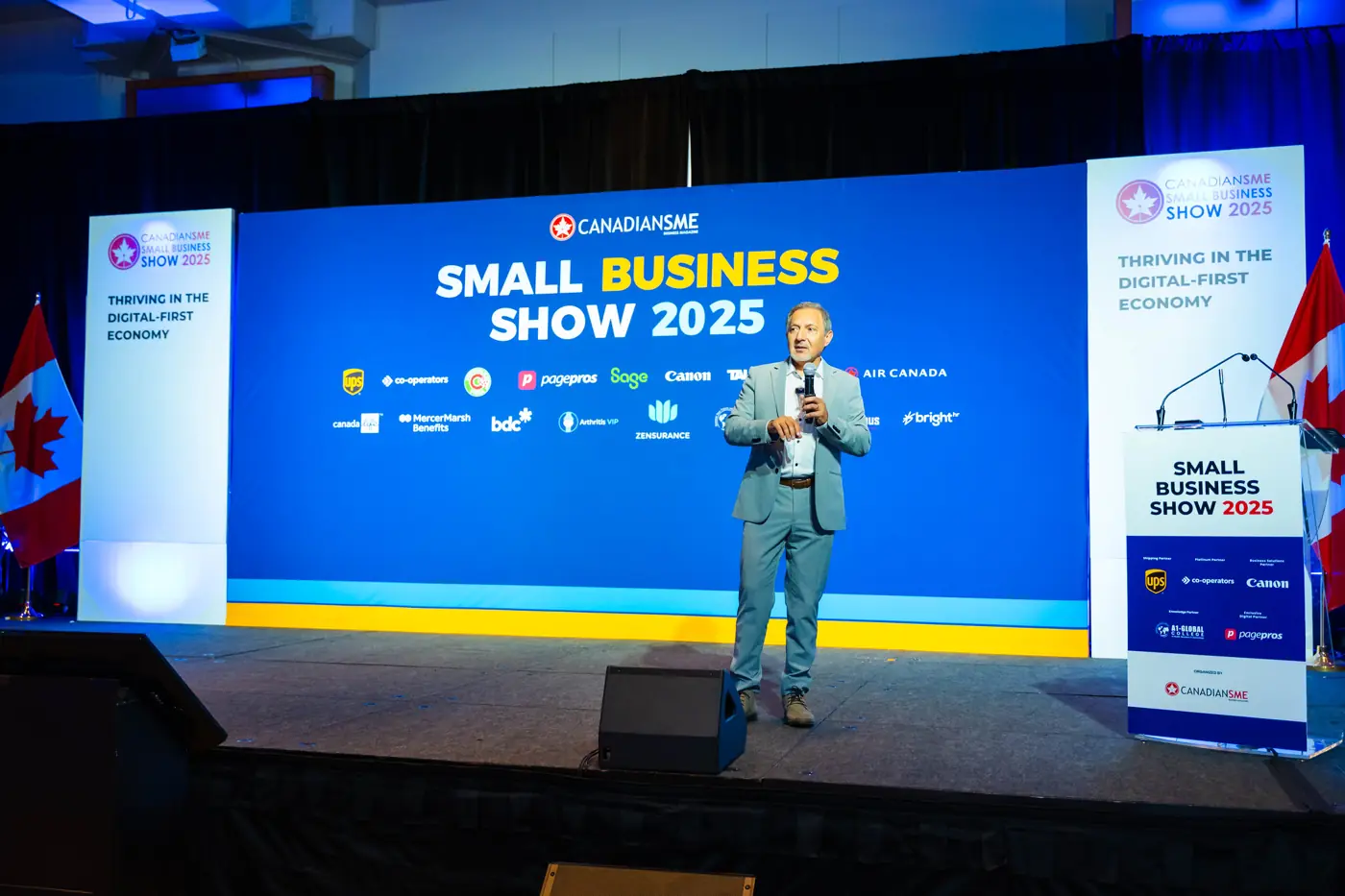 Presenter speaking on stage with a handheld microphone